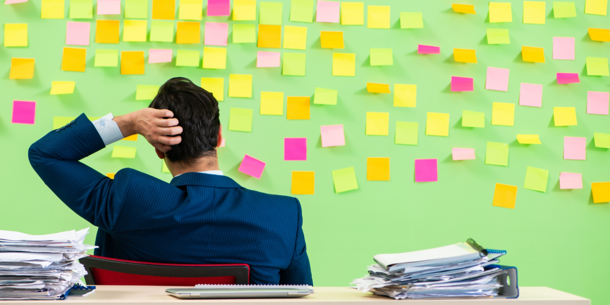 Business person looking at wall of bright post-it notes